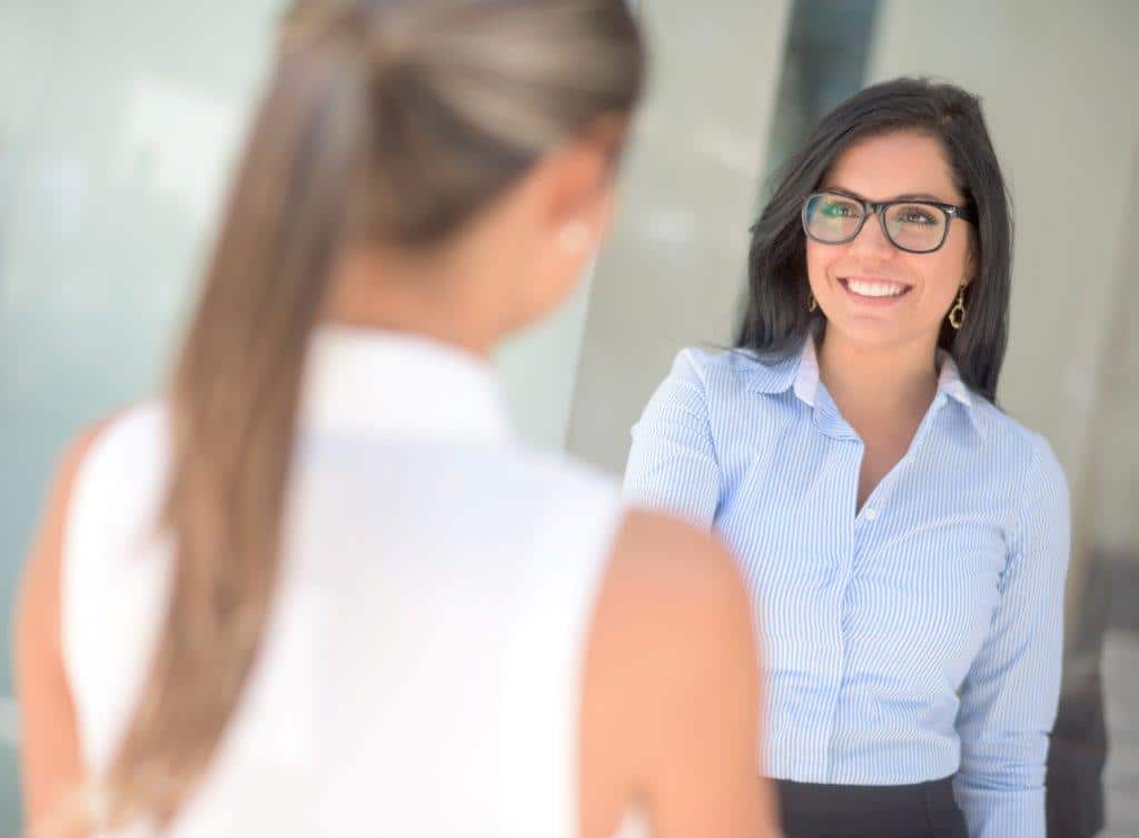 A woman in glasses smiling.