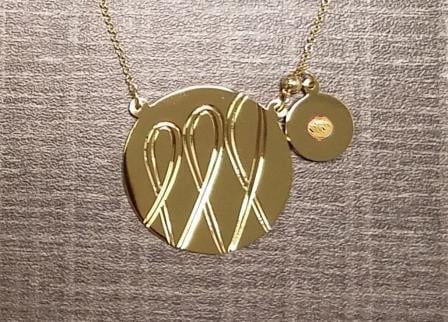 A gold necklace with a circle and a disc.