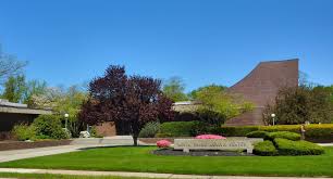 May contain a large building with landscaping and a sign.